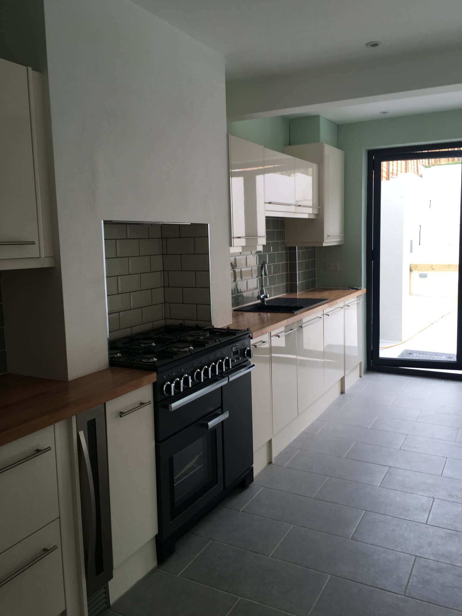 Renovated kitchen with range cooker and tiled splashback