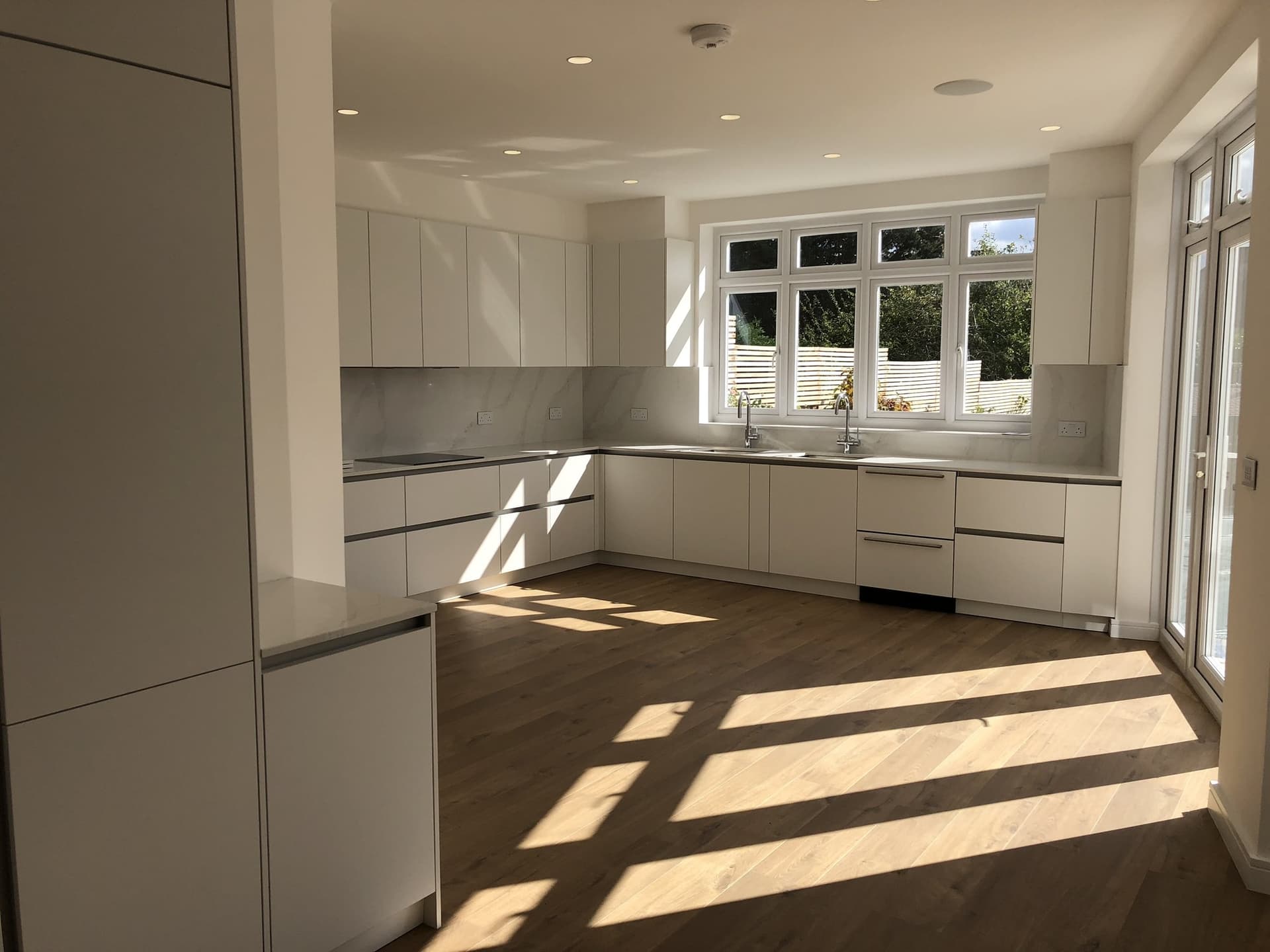 New open-plan kitchen with fitted cabinetry and bi-fold doors onto the garden