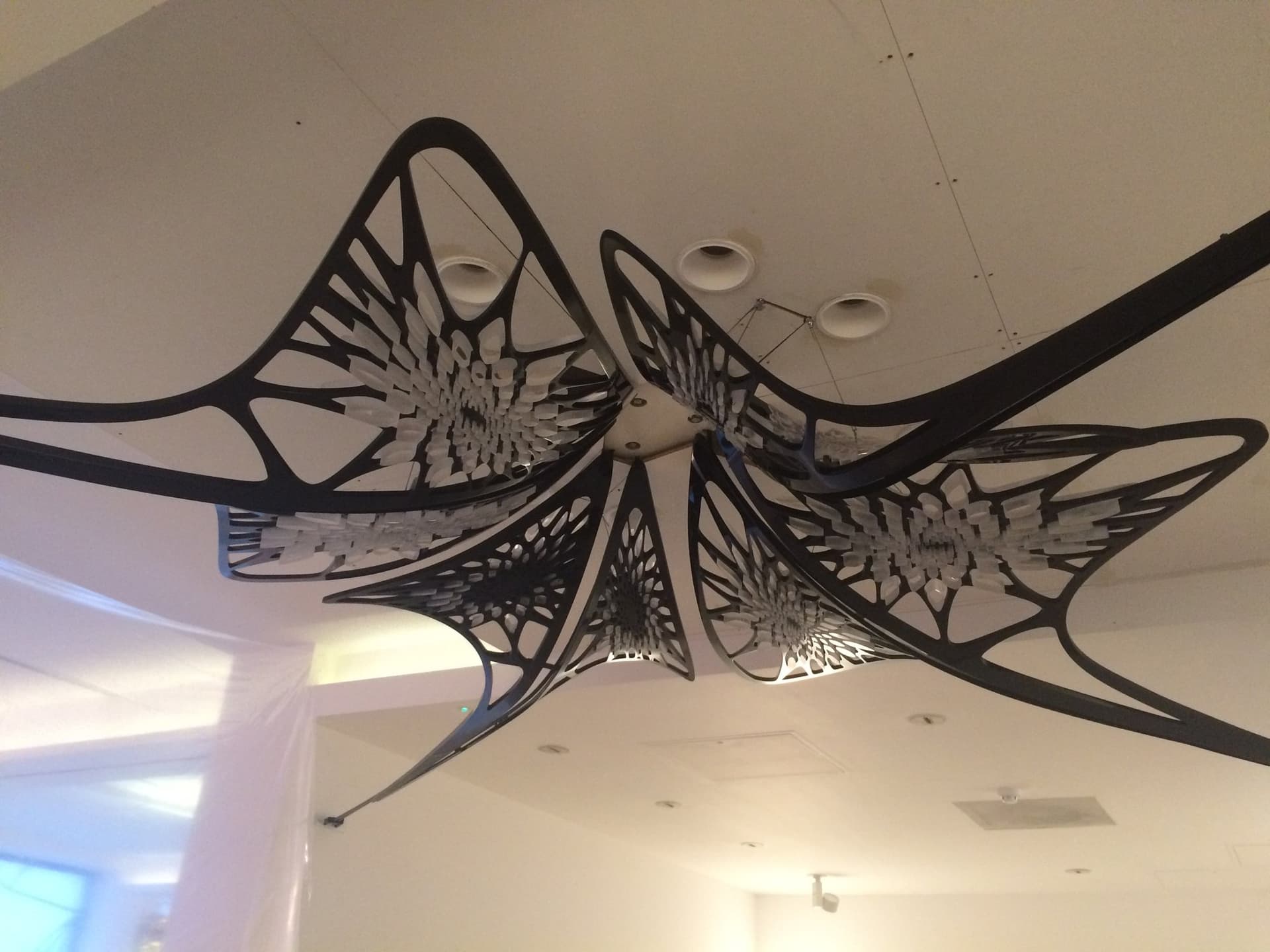Suspended sculptural art piece installed from the gallery ceiling structure