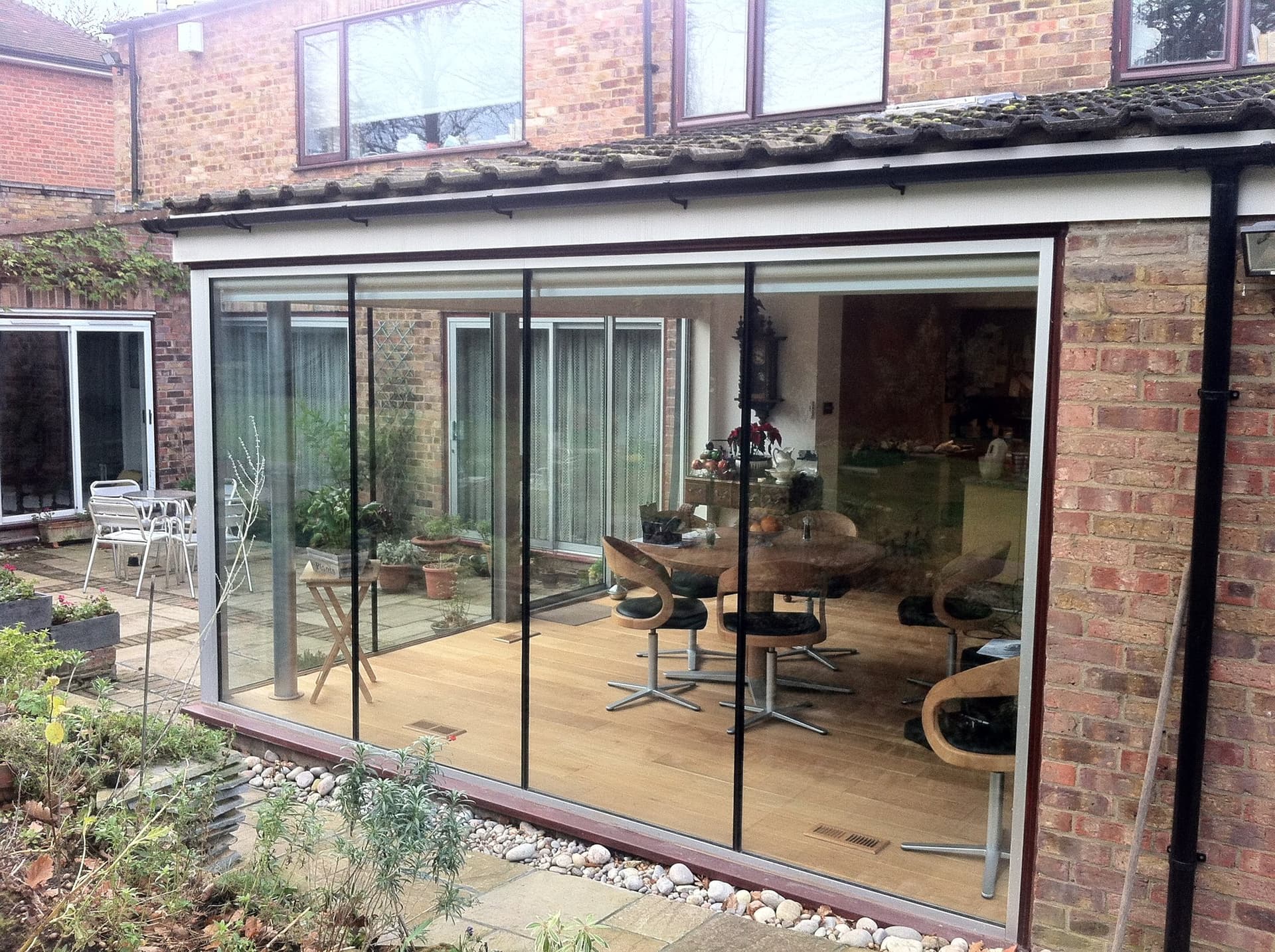 Exterior view of the glazed extension showing the dining area inside