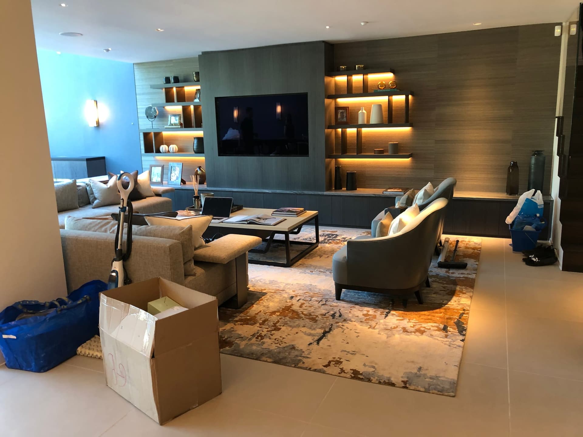 Living room with fitted joinery, backlit shelving and supplied furniture