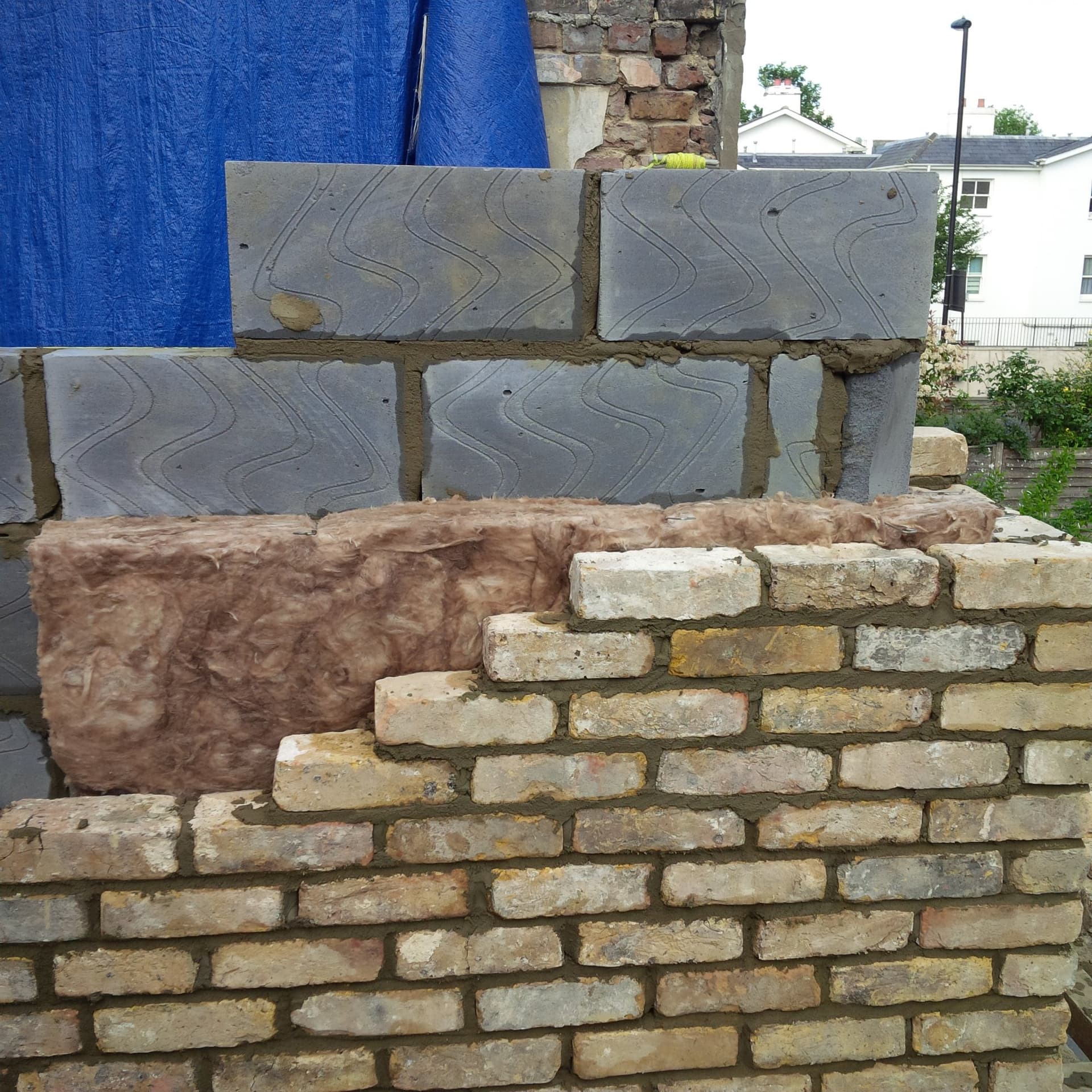Reclaimed brickwork matched in alongside new insulation and blockwork