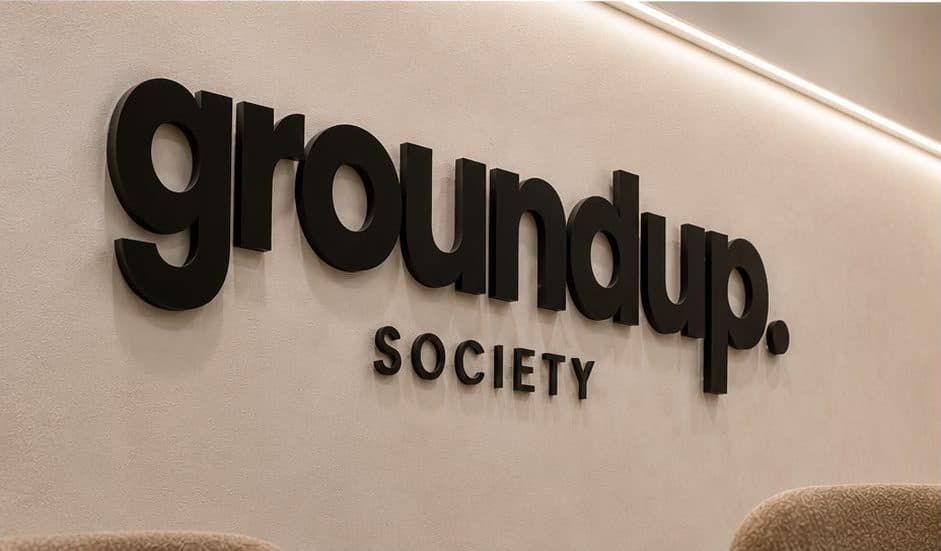 Close-up of the Groundup Society branding and signage detail on the finished feature wall