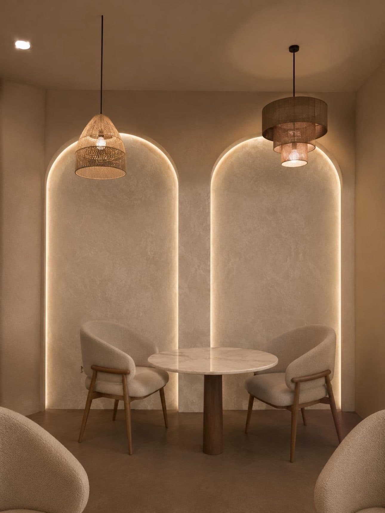 Finished seating nook beneath two illuminated arched wall features with pendant lighting