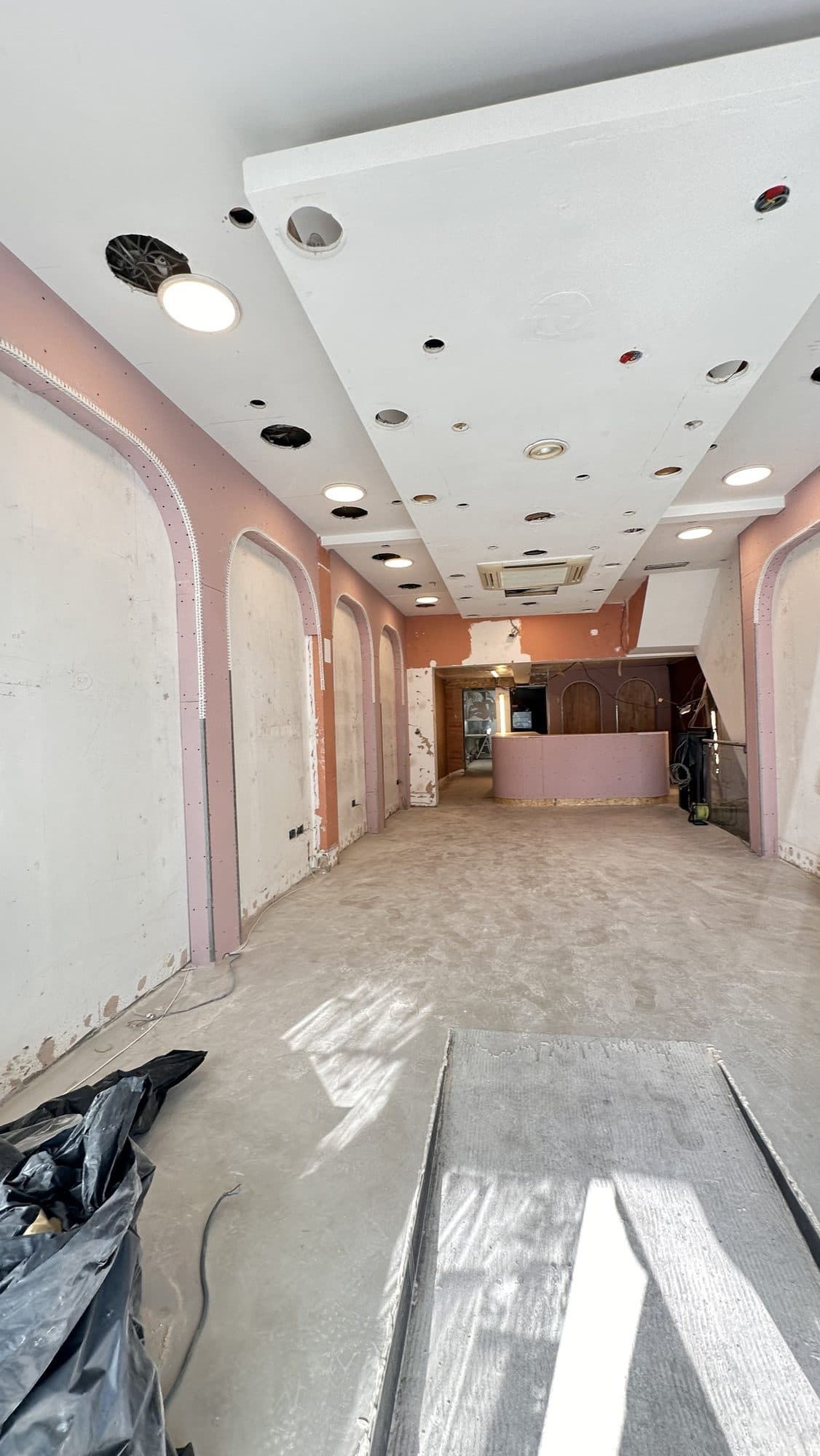 Interior mid strip-out with ceiling service holes cut and new arch framing going in during the early stage of the refurbishment
