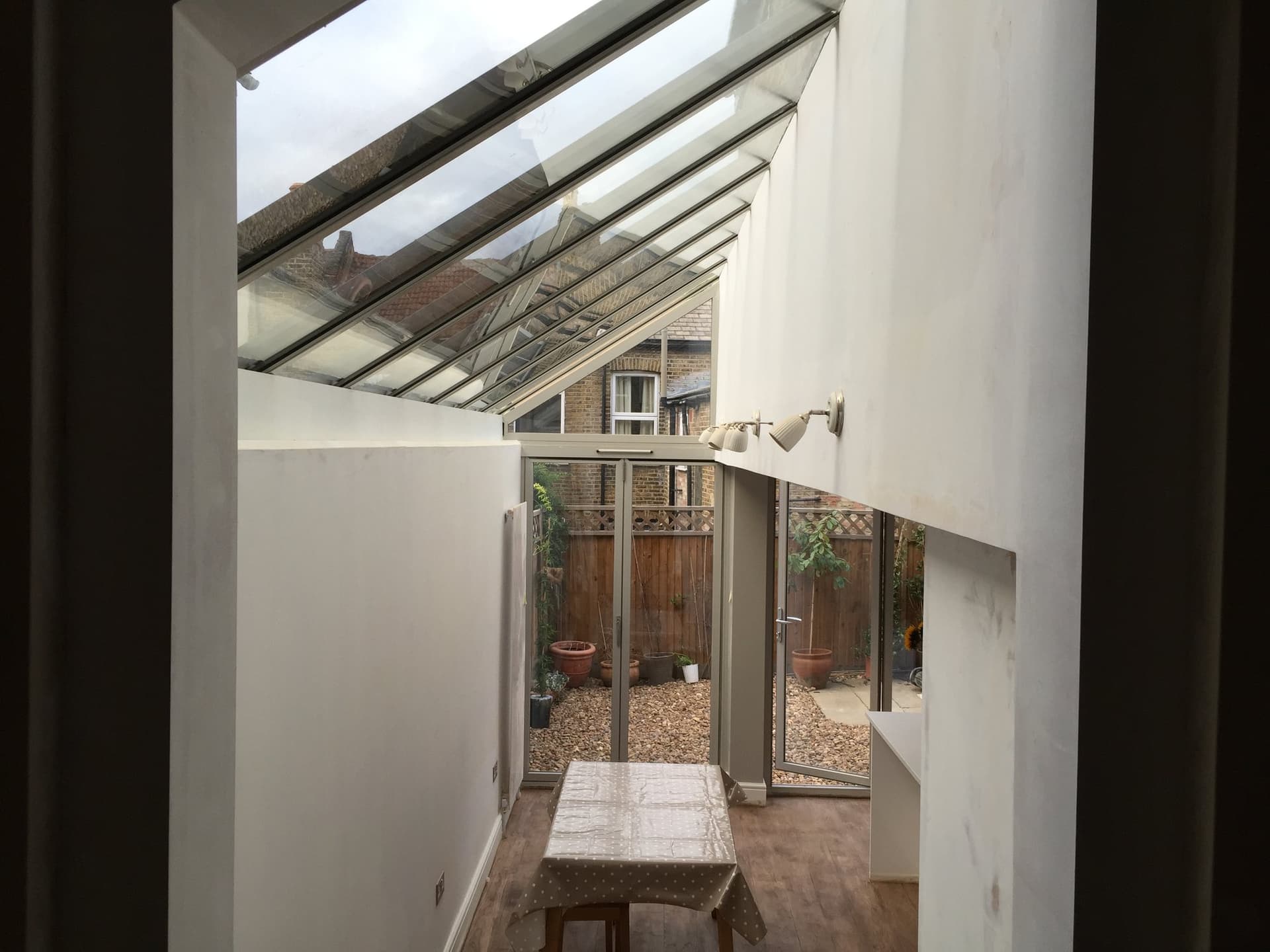 Interior of the glazed extension looking out through bifold doors to the garden