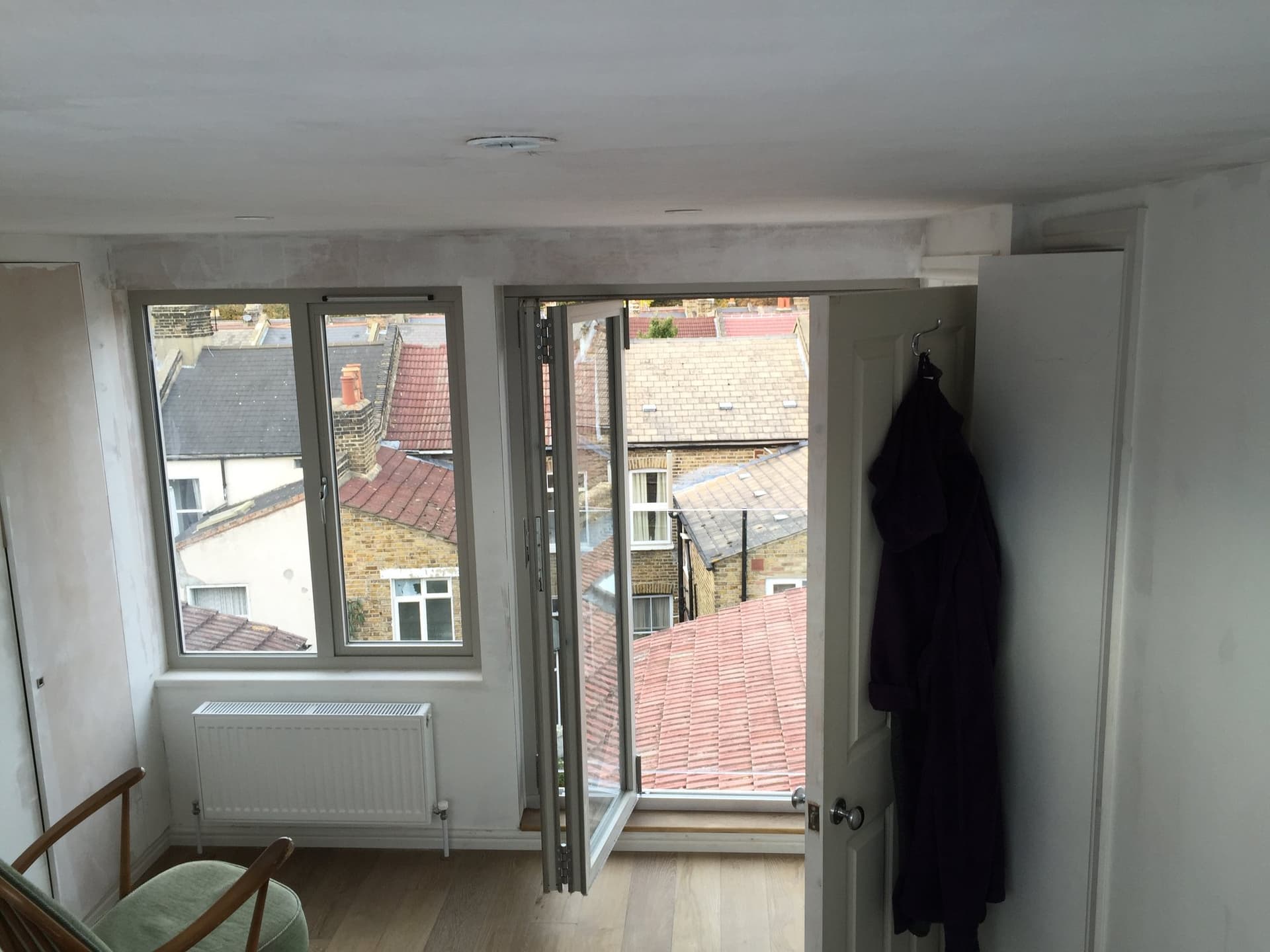 Loft conversion bedroom with Juliet balcony doors opening onto the rooftops