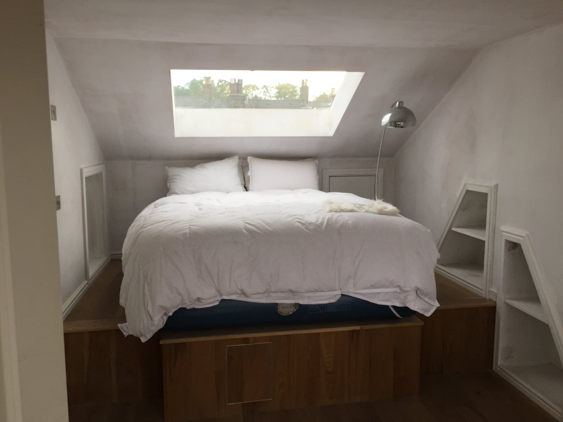 Loft conversion bedroom with a large skylight over the bed