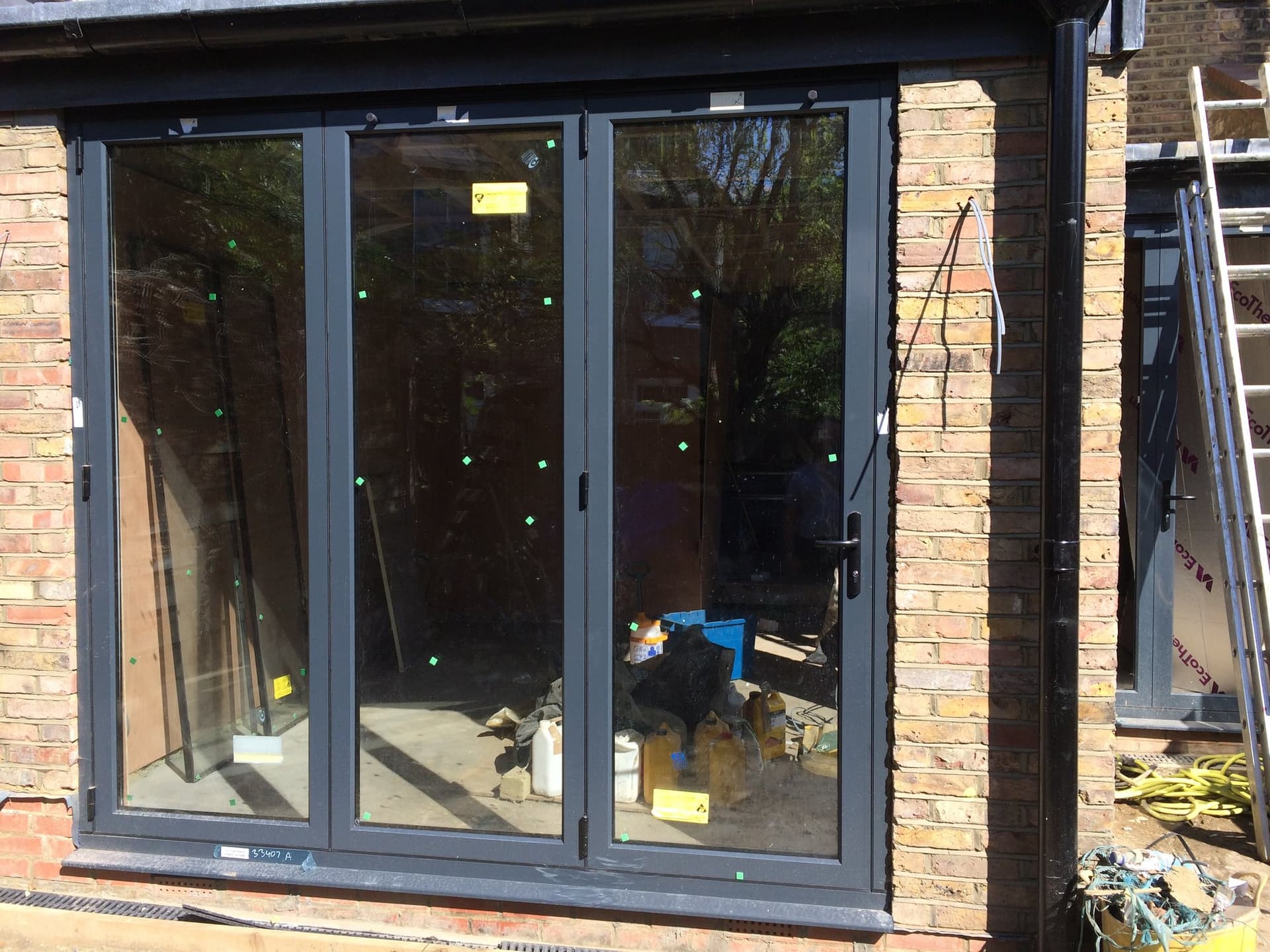 Bifolding doors installed at first-fix stage, protective film still in place