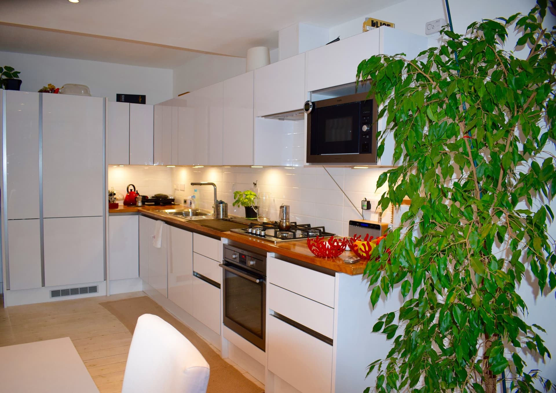 Compact high-gloss white kitchen fitted into a London apartment