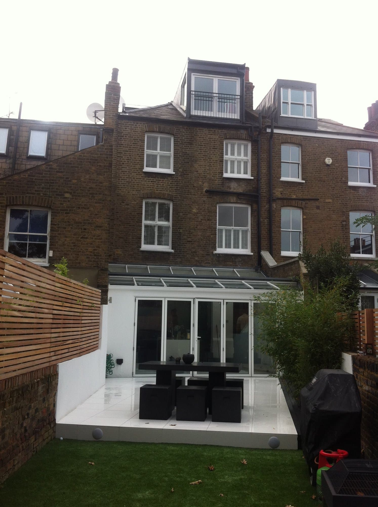 Rear of a Fulham terraced house showing a new loft dormer with Juliet balcony above a glazed roof extension