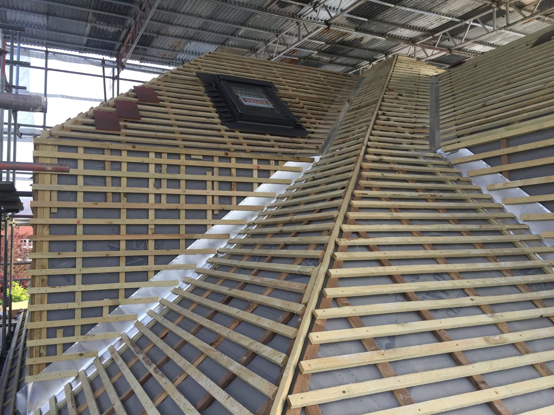 Roof structure under construction during the loft conversion, with a Velux window being fitted