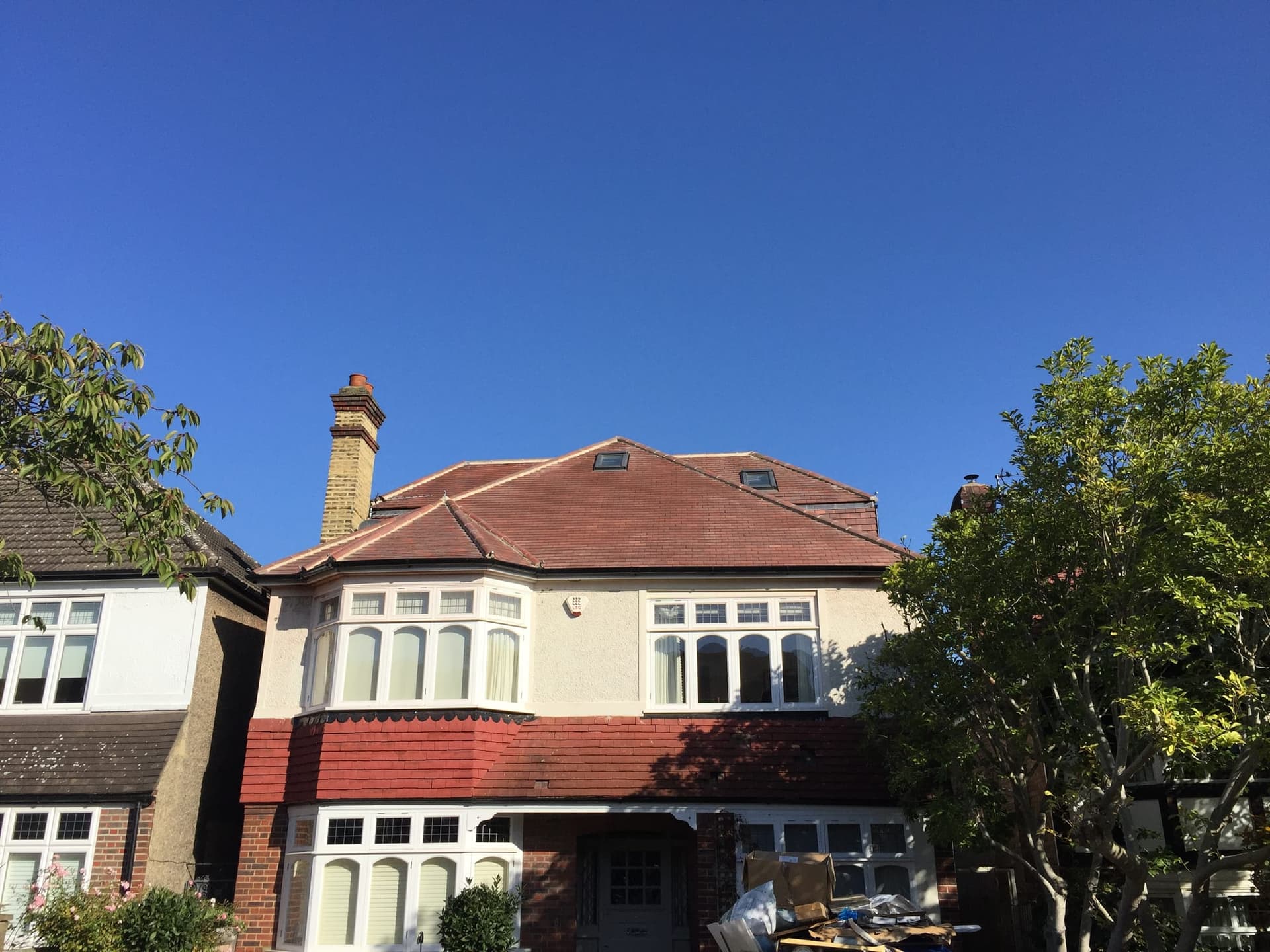 Large detached Wimbledon house with a hipped tile roof and loft conversion rooflights