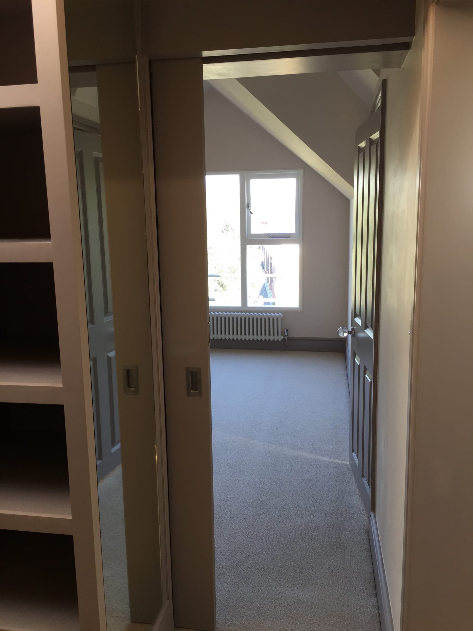 Finished loft bedroom with fitted wardrobes and dormer window