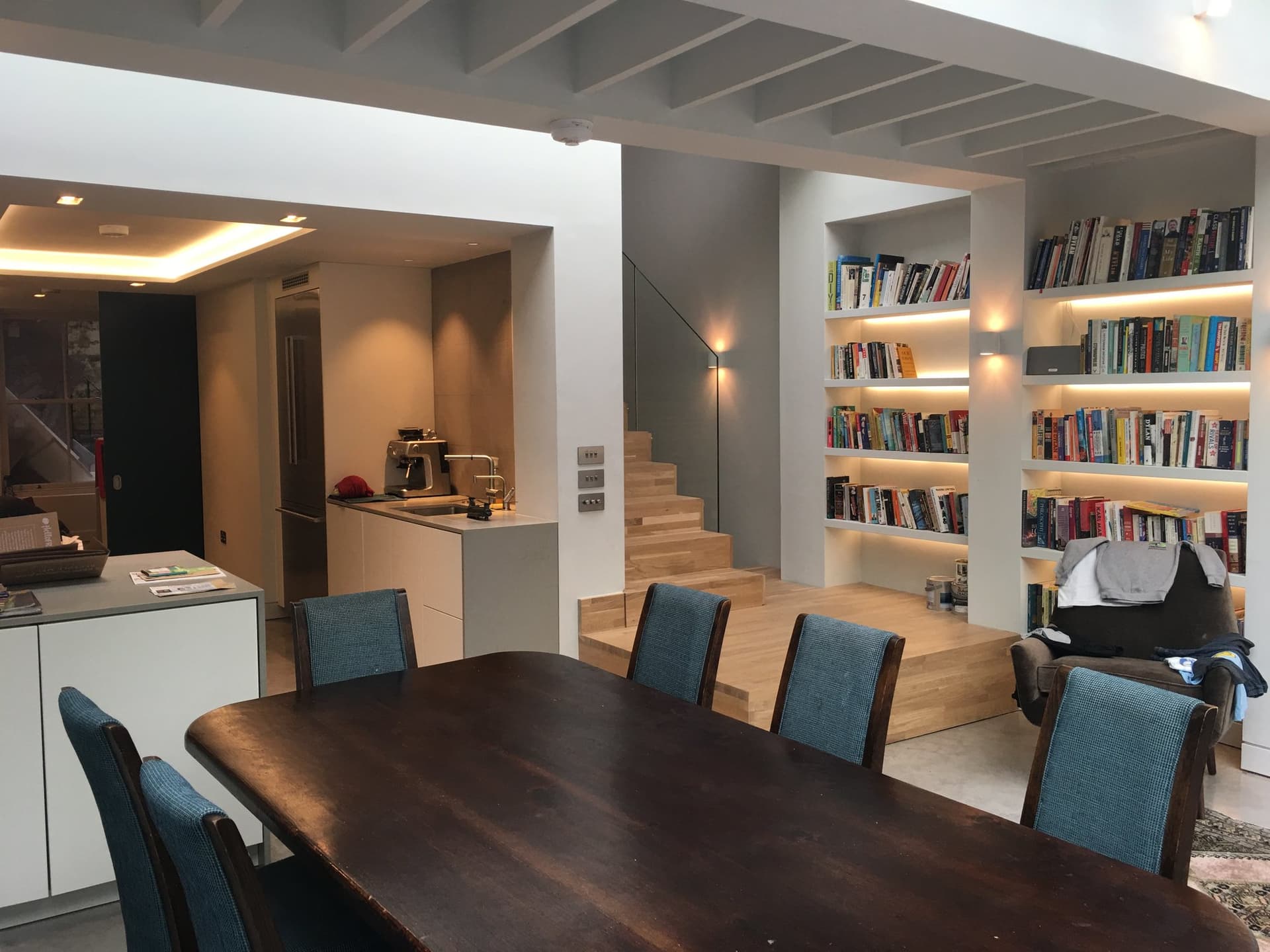 Open-plan kitchen, dining area and built-in bookshelves within the renovated house