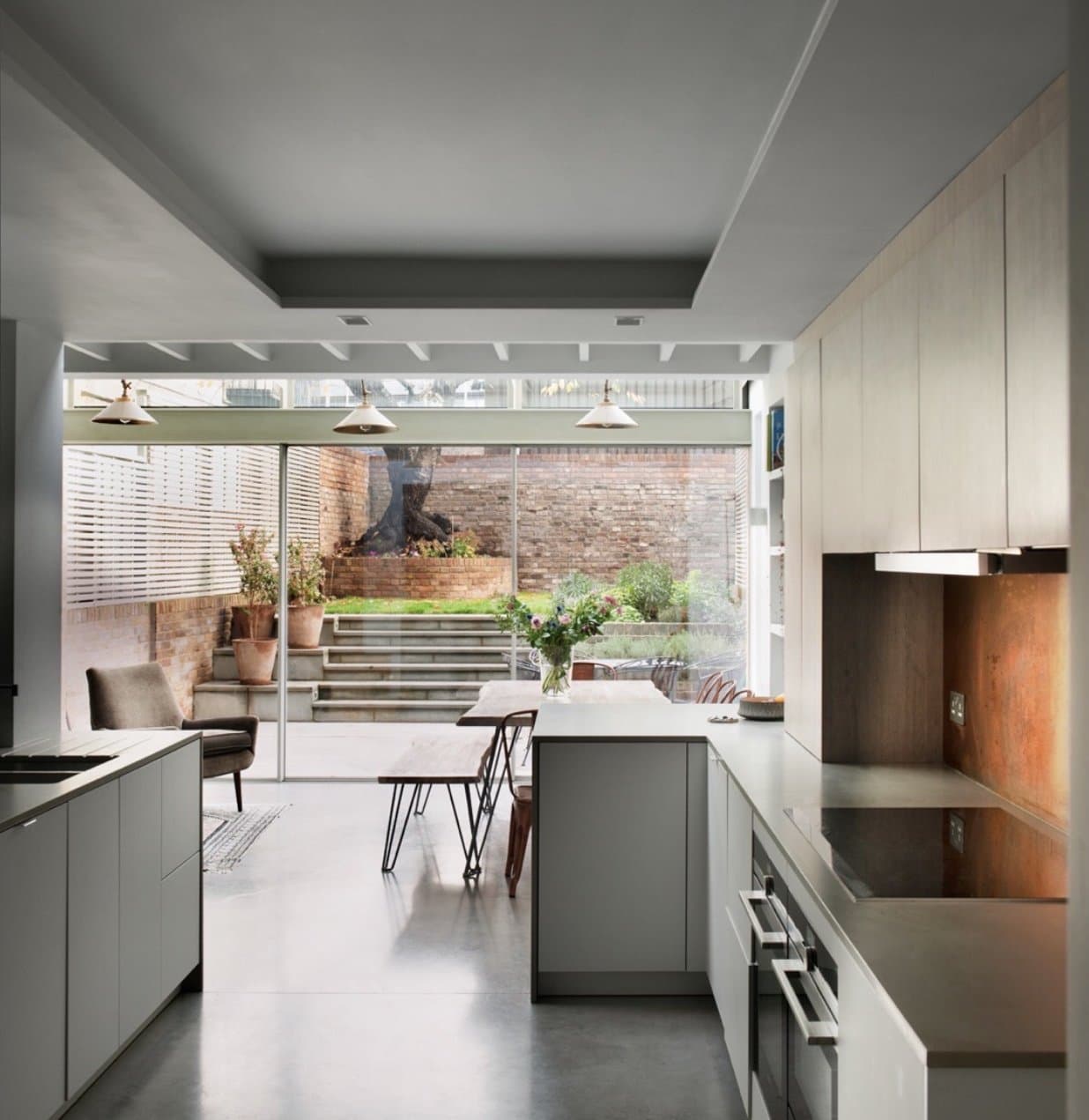 Kitchen extension with a glazed roof, oak cabinetry and a copper splashback, opening onto the garden