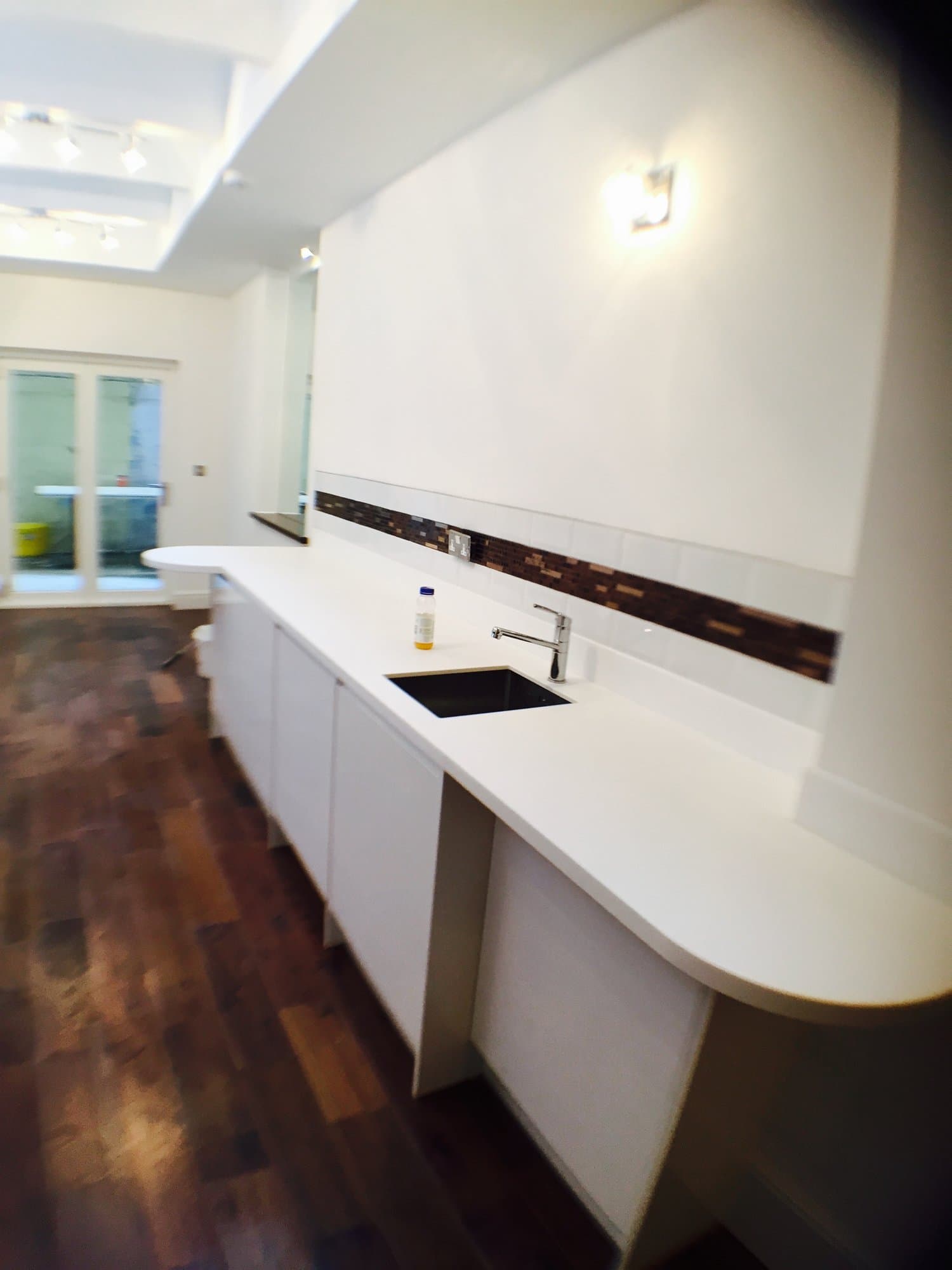Curved white quartz breakfast bar in a remodelled luxury kitchen
