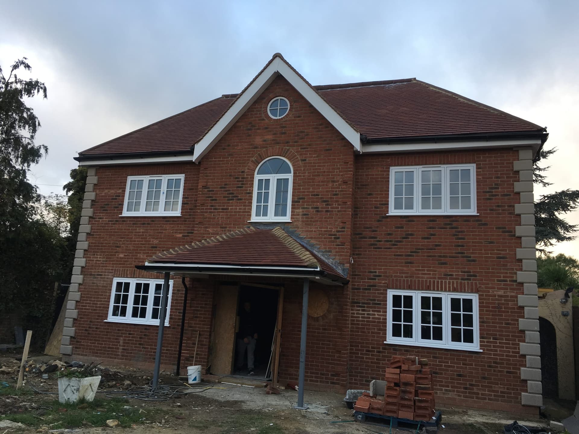 Completed brick shell of a new-build house in Hornchurch with tiled roof and porch canopy