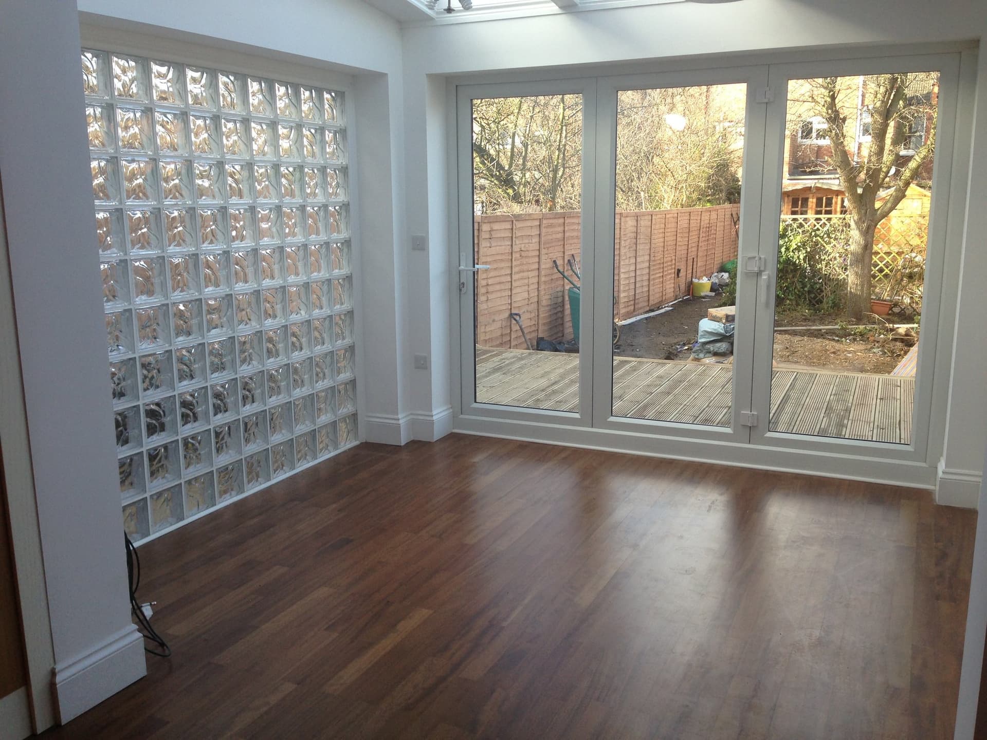 Kitchen extension with a full-height glass block feature wall and bi-fold doors opening onto the garden