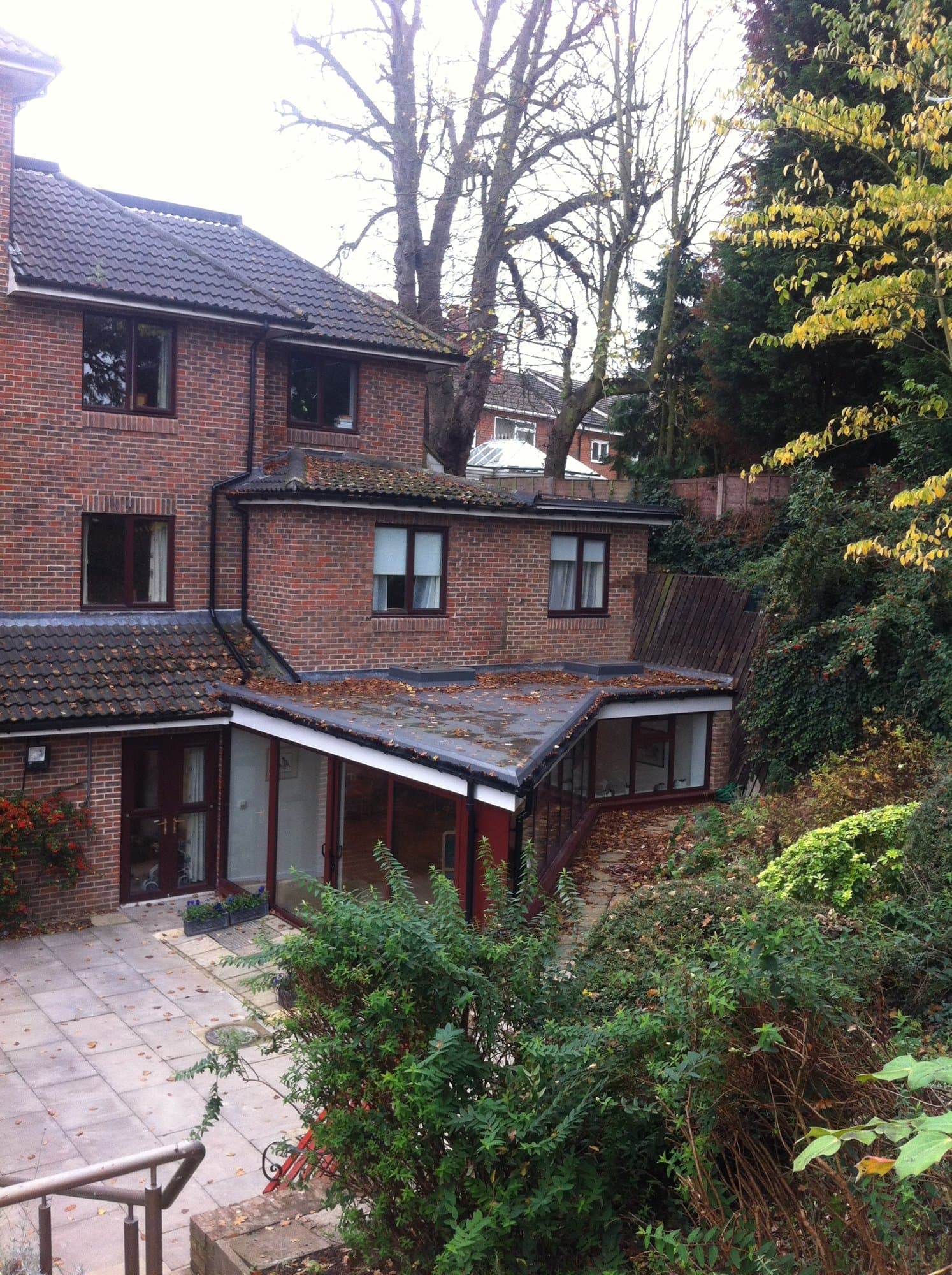 Elevated view of the extension's flat roof and the terraced garden behind it