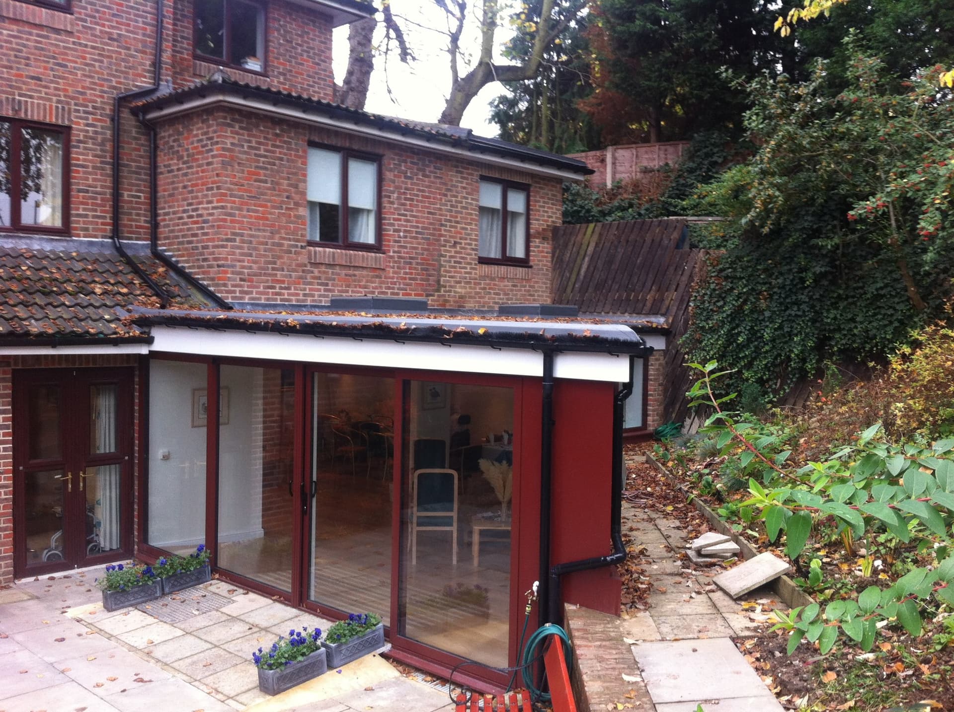 Patio-level view of the extension's bifolding doors and flat GRP roof