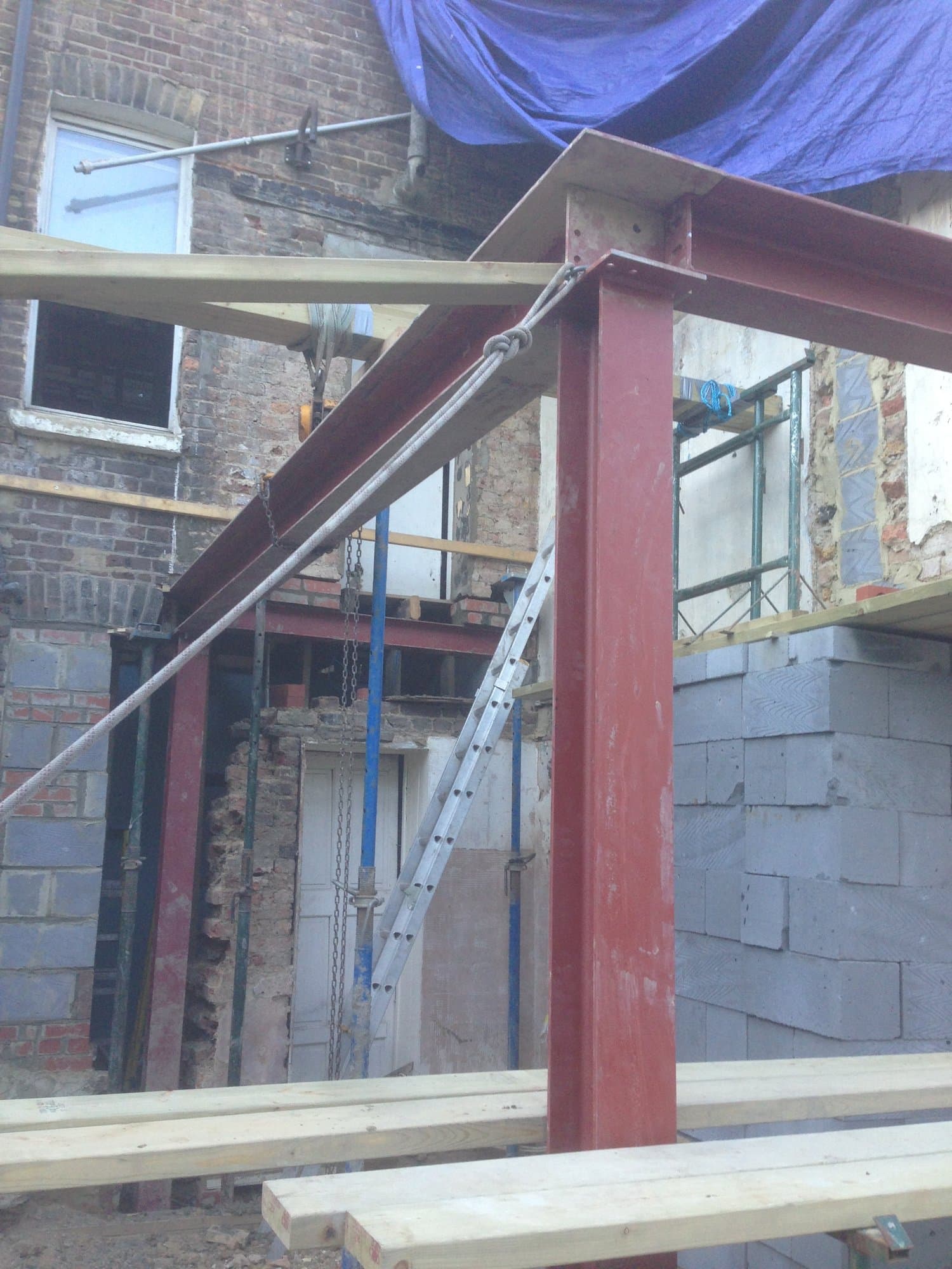 Close-up of a structural steel column and beam junction during a rear extension build