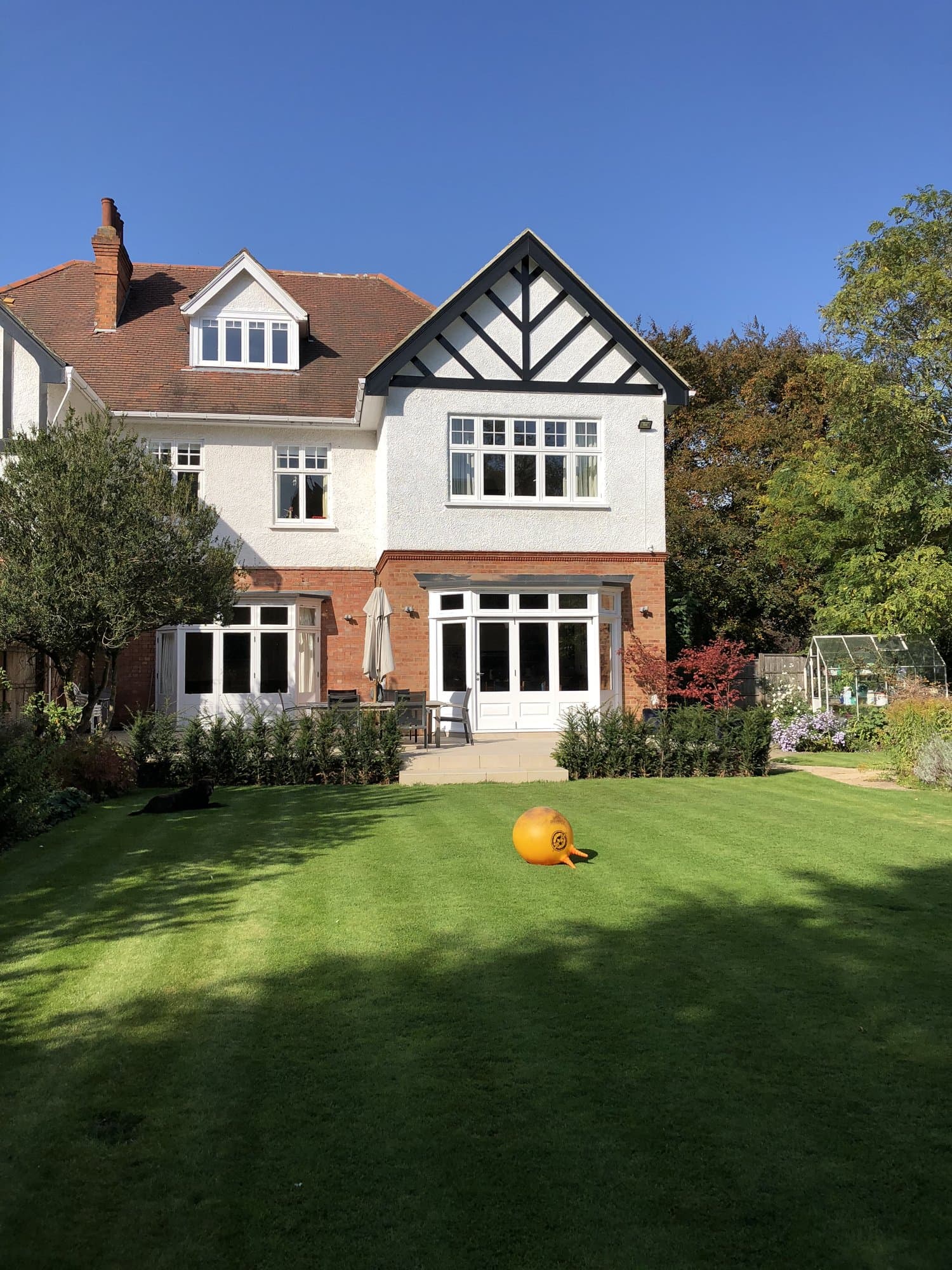 Completed Tudor-style wing extension added to a large family home in Hampstead, under a clear blue sky