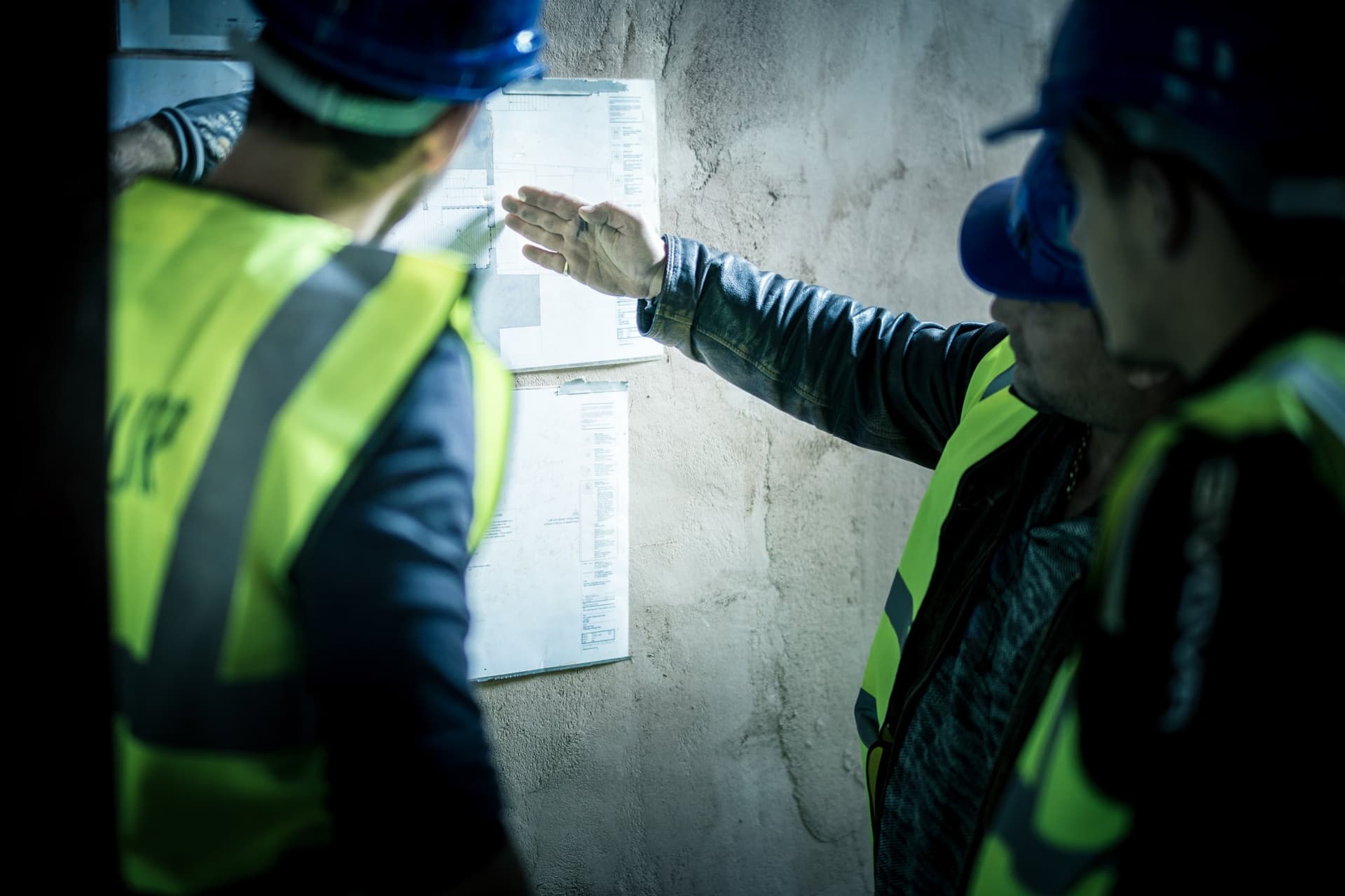 Two TopBuild UK team members reviewing architect's drawings on site